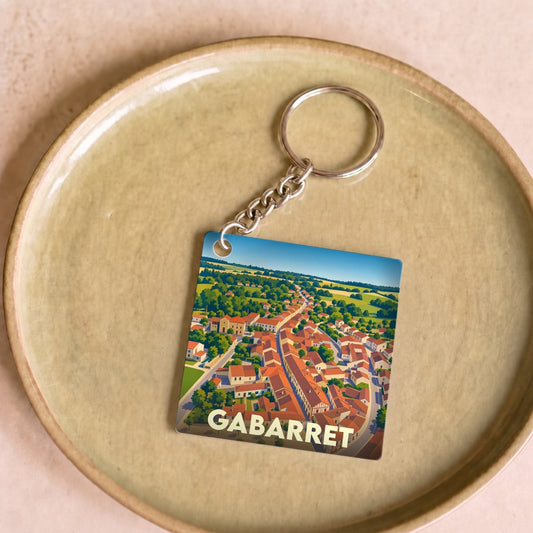 Porte-clés souvenir de la ville de Gabarret avec une illustration aérienne stylisée.