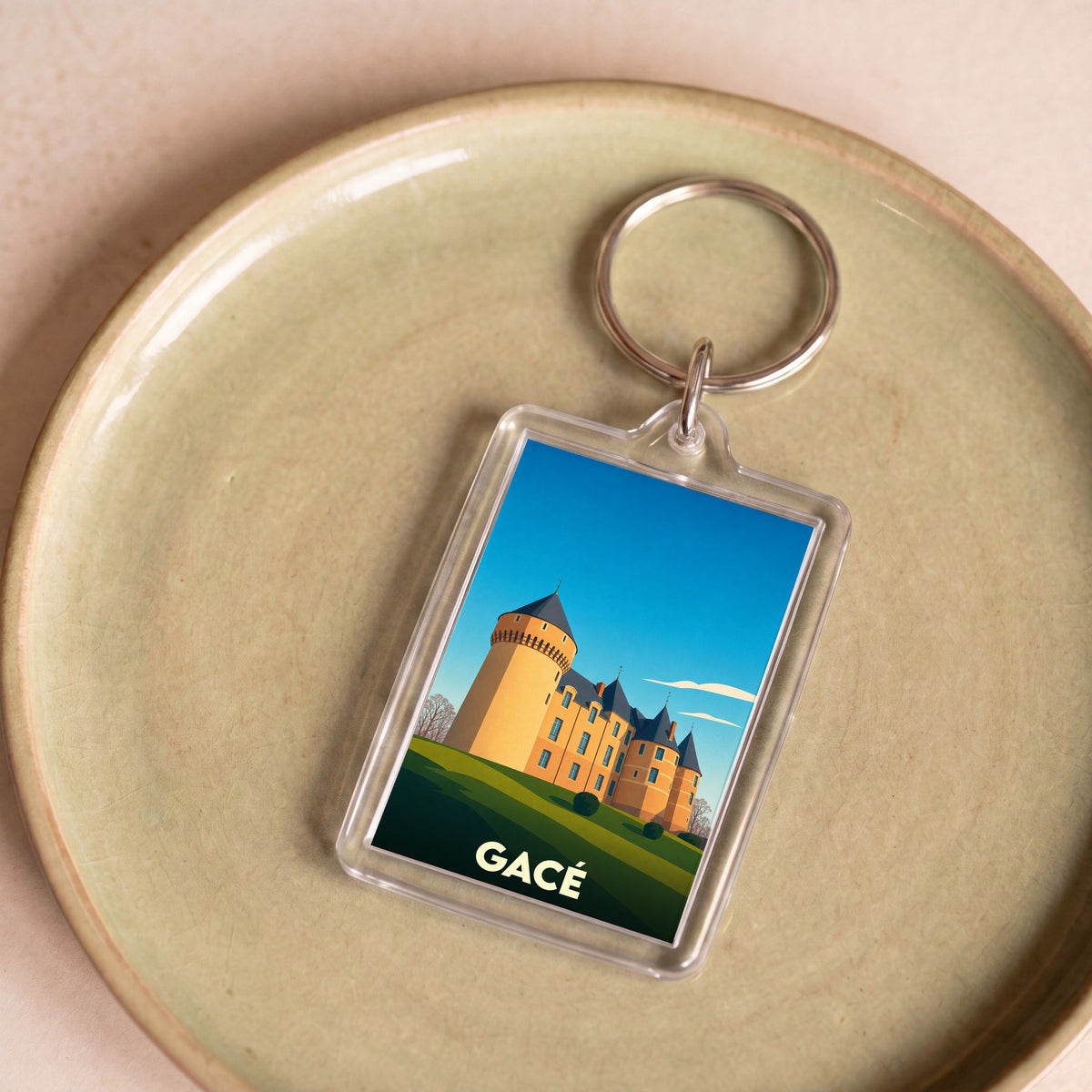 Porte-clés souvenir de la ville de Gacé avec une illustration stylisée de son château.