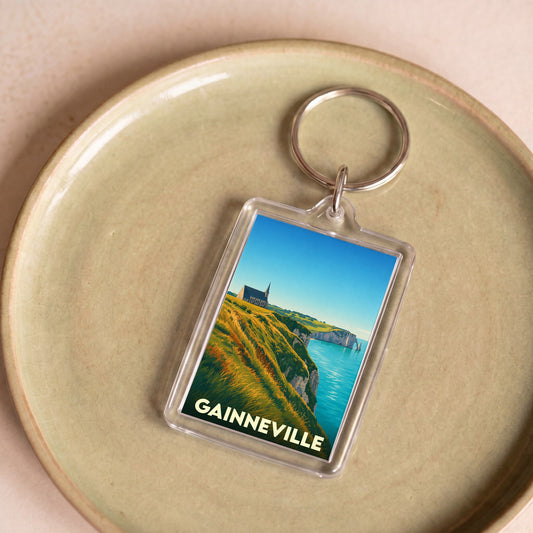 Porte-clés souvenir de la ville de Gainneville avec une illustration stylisée de falaises en bord de mer.
