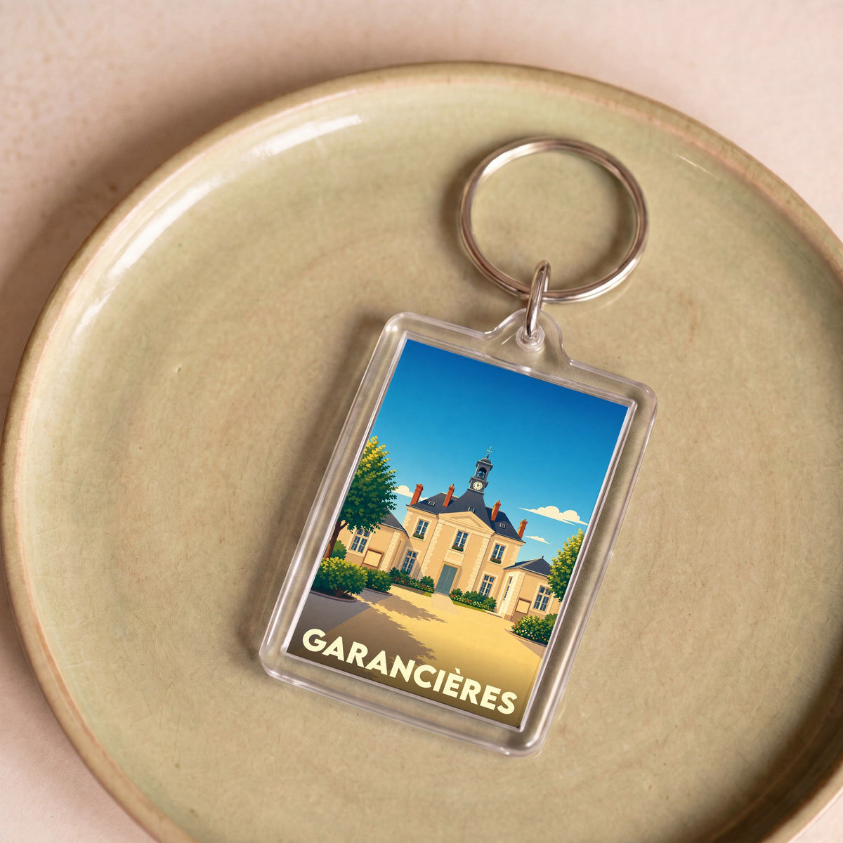 Porte-clés souvenir de la ville de Garancières avec une illustration stylisée de la mairie.