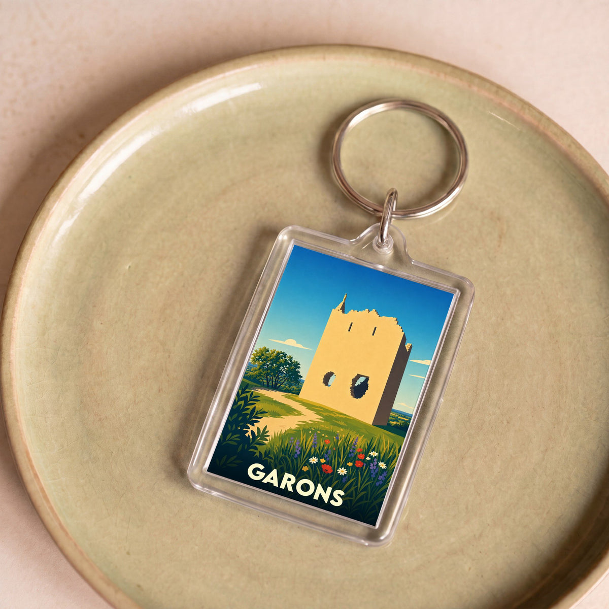 Porte-clés souvenir de la ville de Garons avec une illustration stylisée d'une tour historique.