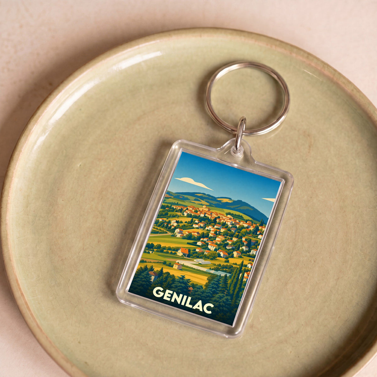 Porte-clés souvenir de la ville de Genilac avec une illustration stylisée de son paysage vallonné.