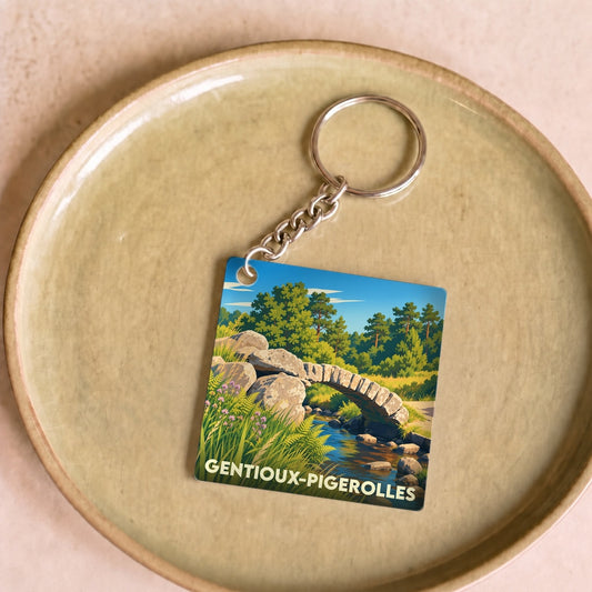 Porte-clés souvenir de la ville de Gentioux-Pigerolles avec une illustration stylisée d'un pont en pierre sur une rivière.