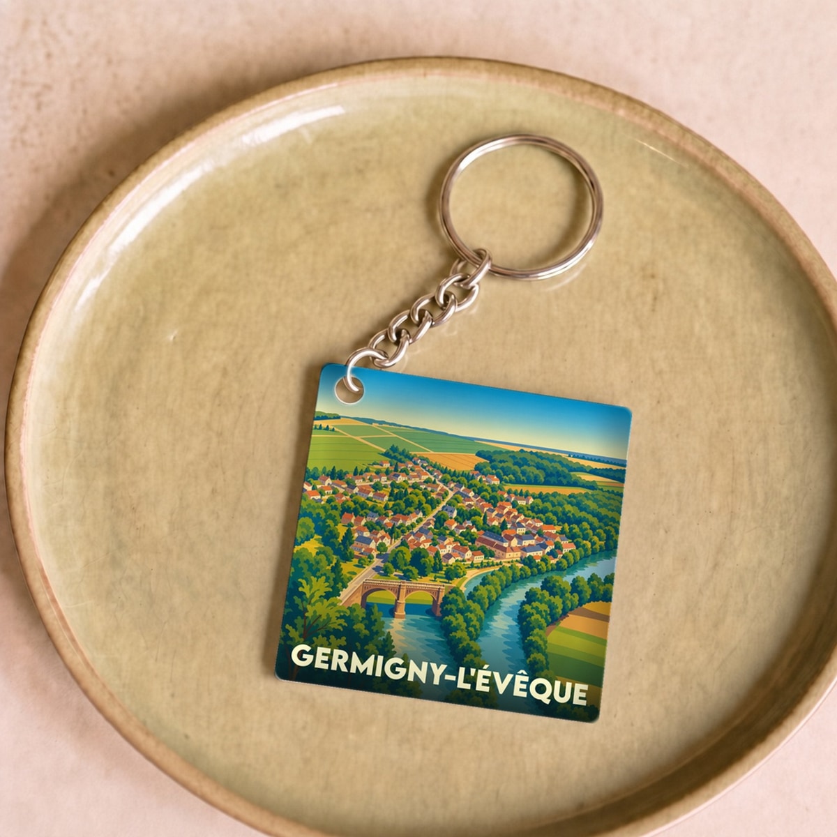 Porte-clés souvenir de la ville de Germigny-l'Évêque avec une illustration stylisée.