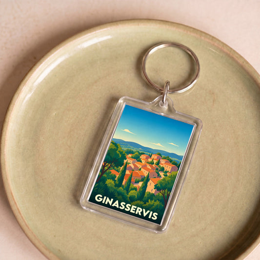 Porte-clés souvenir de la ville de Ginasservis avec une illustration stylisée de son village provençal.