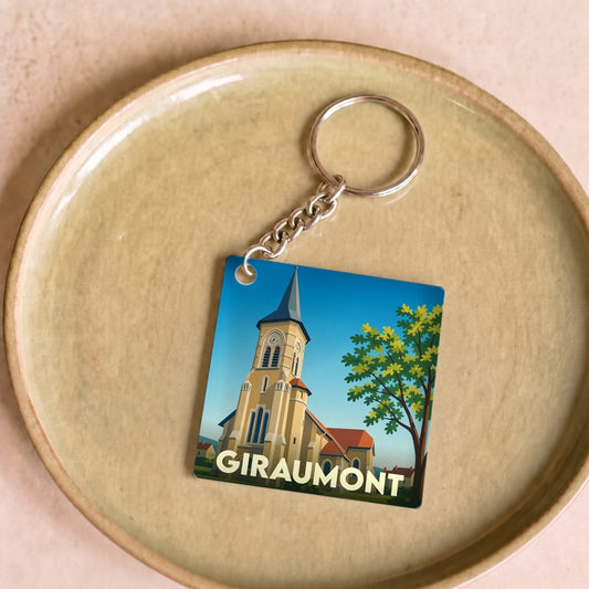 Porte-clés souvenir de la ville de Giraumont avec une illustration stylisée de son église.