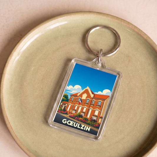 Porte-clés souvenir de la ville de Gœulzin avec une illustration stylisée de sa mairie.