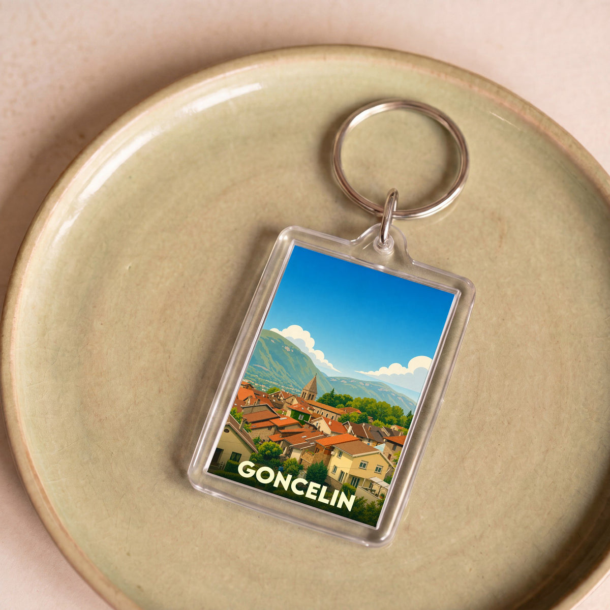 Porte-clés souvenir de la ville de Goncelin avec une illustration stylisée.