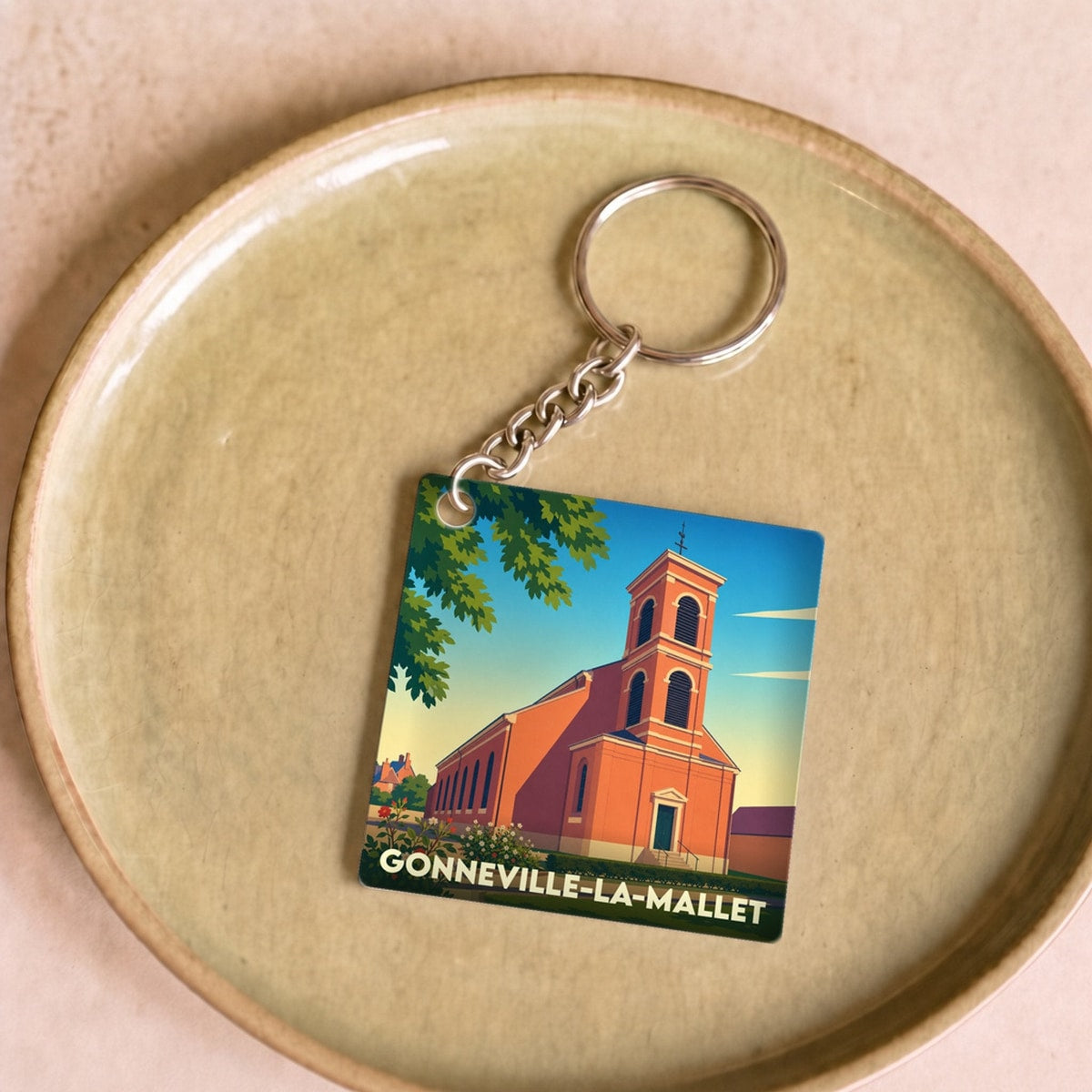 Porte-clés souvenir de la ville de Gonneville-la-Mallet avec une illustration stylisée de son église.