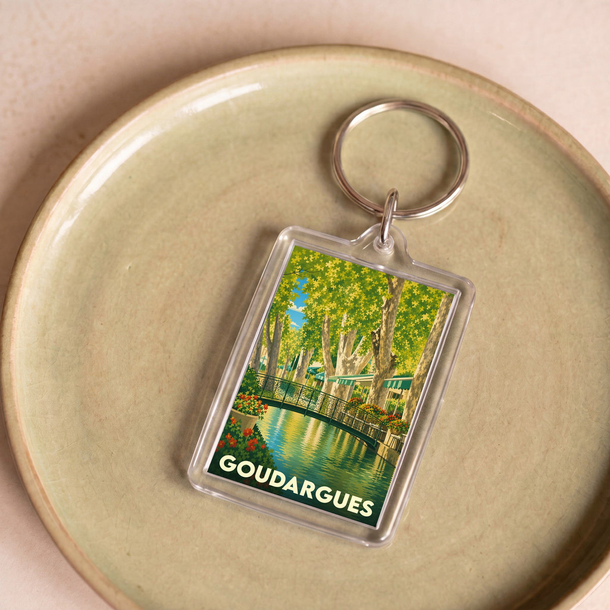 Porte-clés souvenir de la ville de Goudargues avec une illustration stylisée.