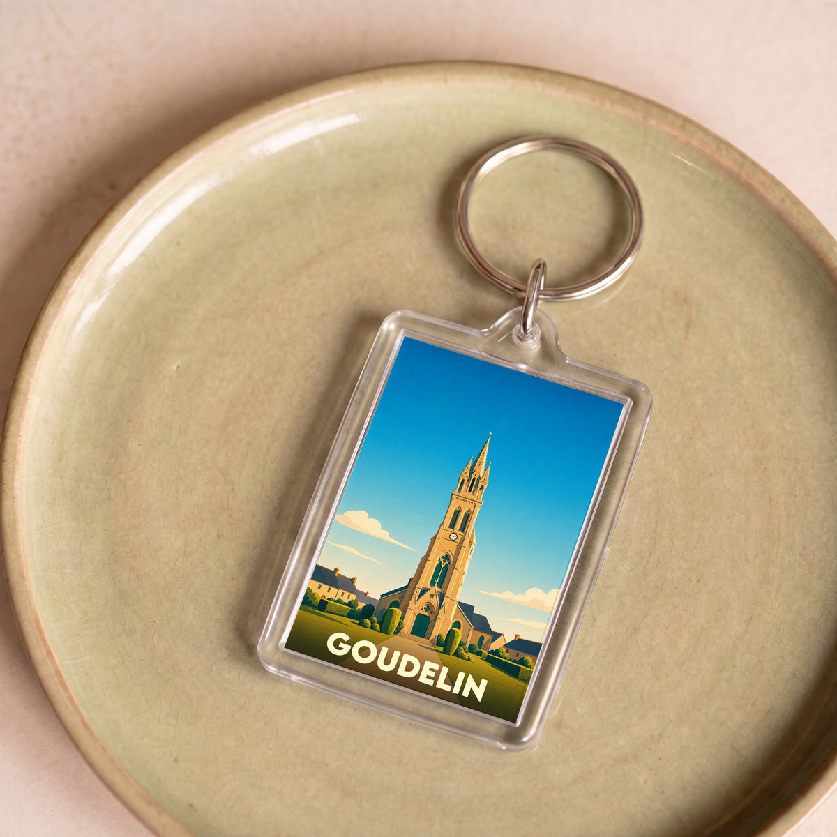 Porte-clés souvenir de la ville de Goudelin avec une illustration stylisée de son église.