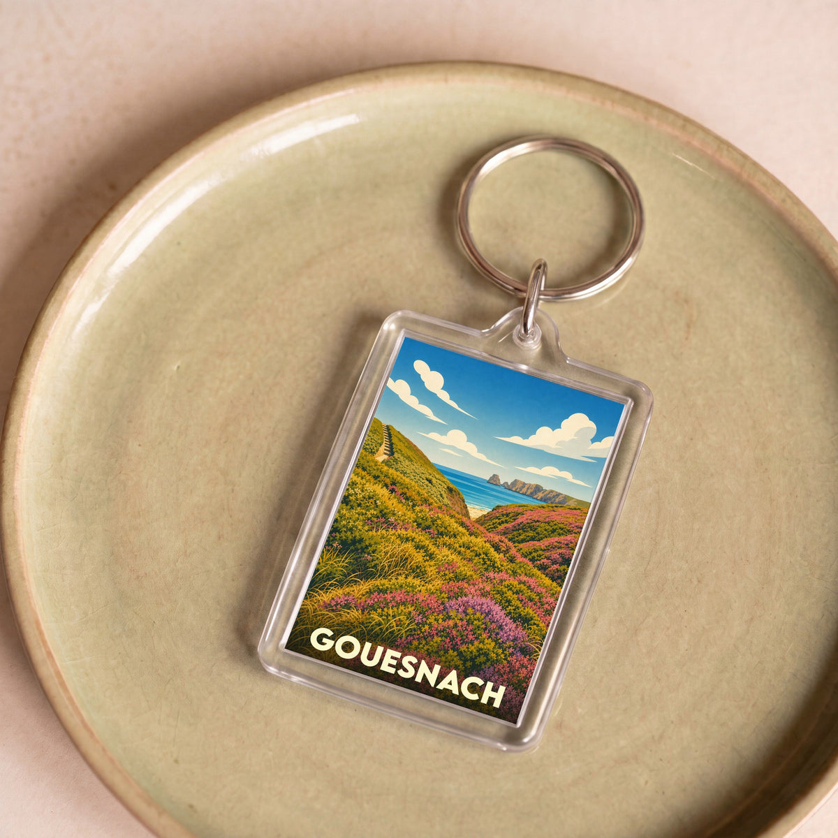 Porte-clés souvenir de la ville de Gouesnach avec une illustration stylisée d'un paysage côtier fleuri.