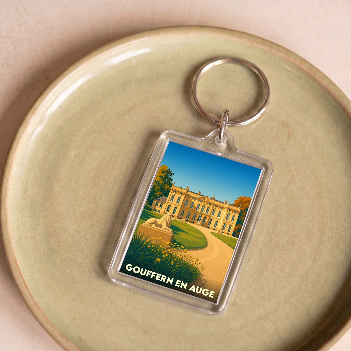 Porte-clés souvenir de la ville de Gouffern en Auge avec une illustration stylisée d'un château.