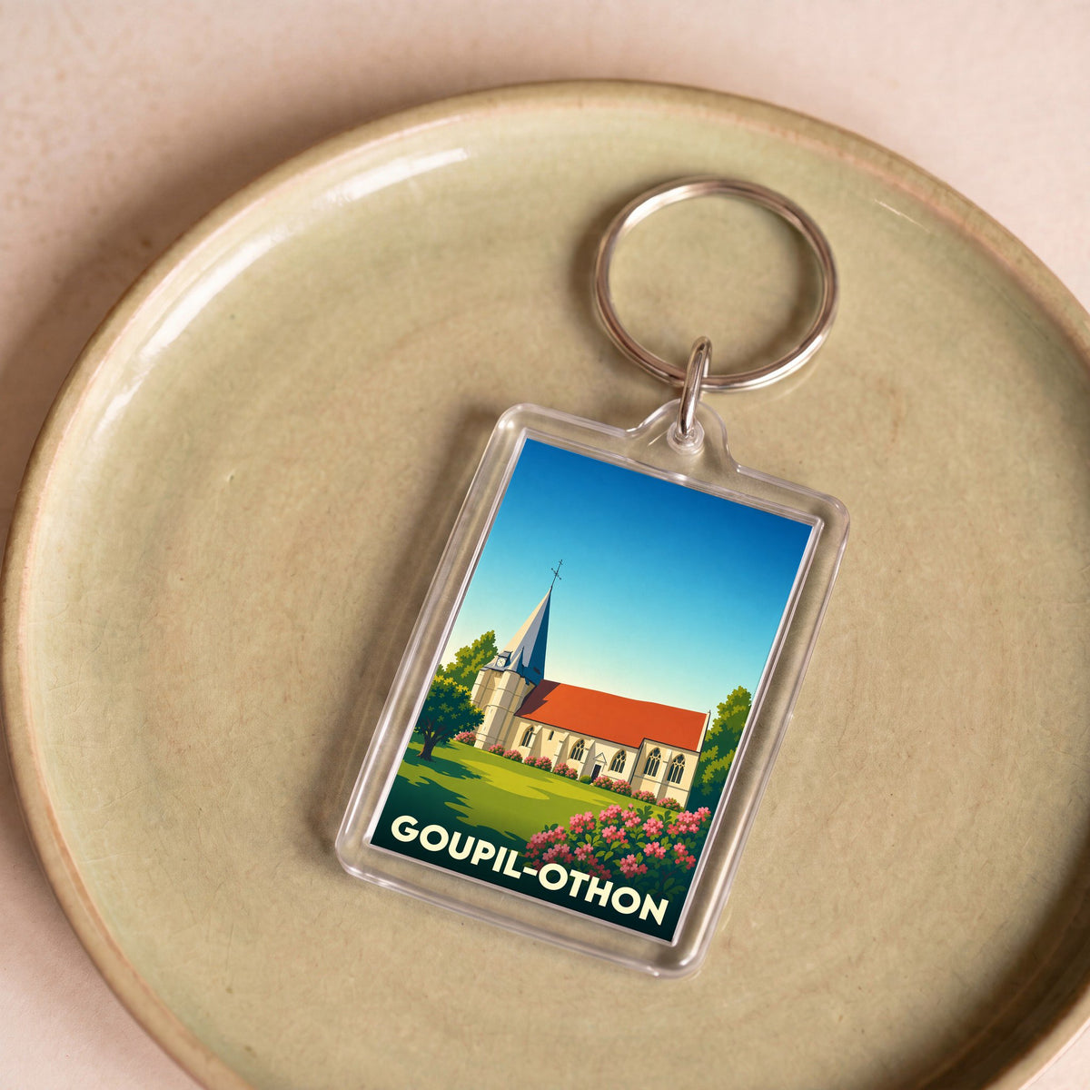 Porte-clés souvenir de la commune de Goupil-Othon avec une illustration stylisée de son église.