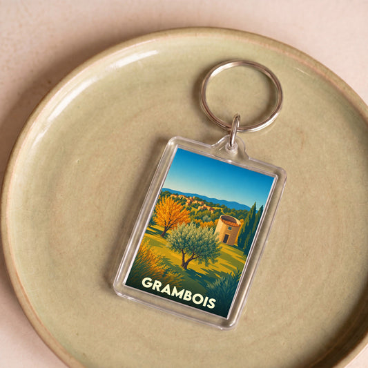 Porte-clés souvenir de la ville de Grambois avec une illustration stylisée d'un paysage provençal.