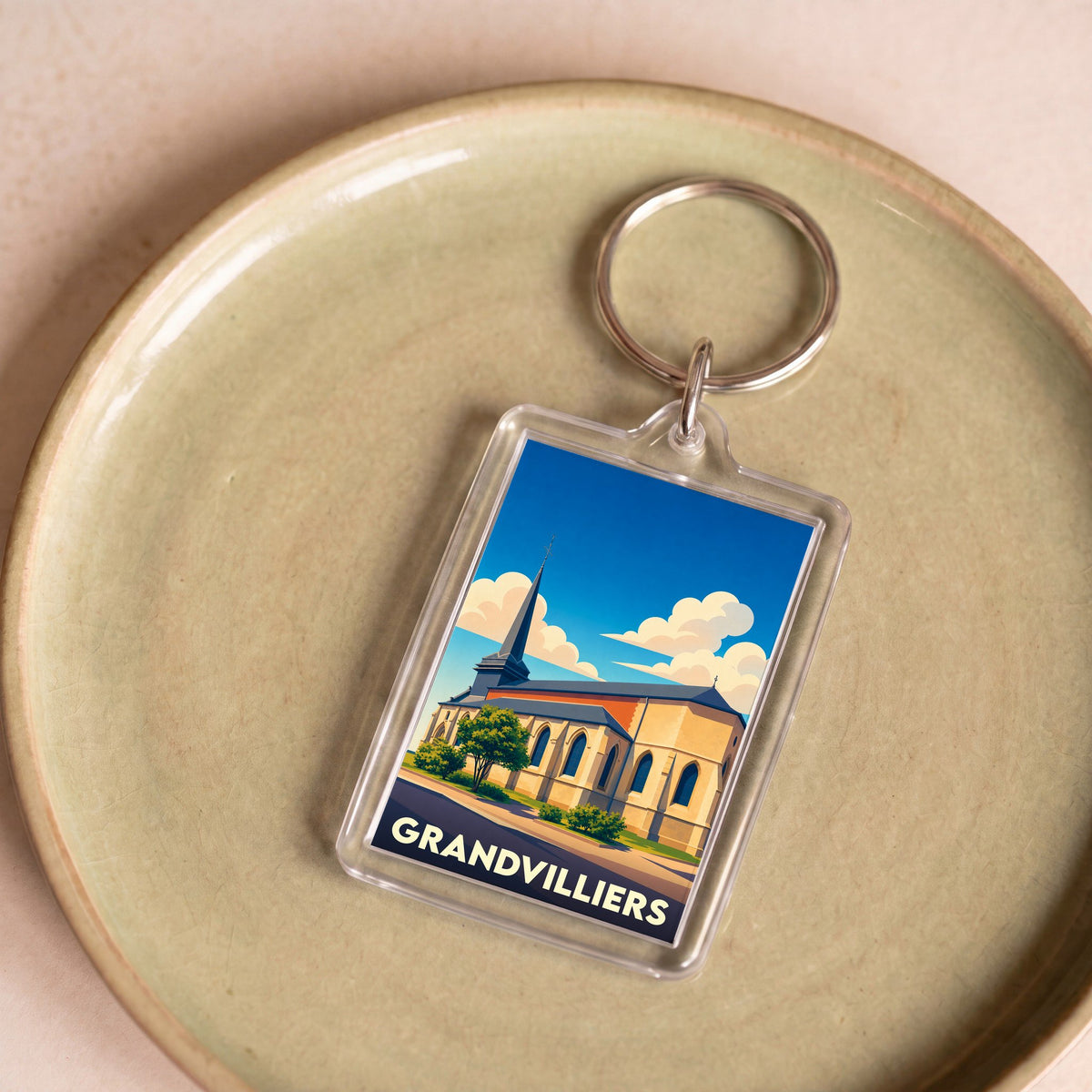 Porte-clés souvenir de la ville de Grandvilliers avec une illustration stylisée de son église.
