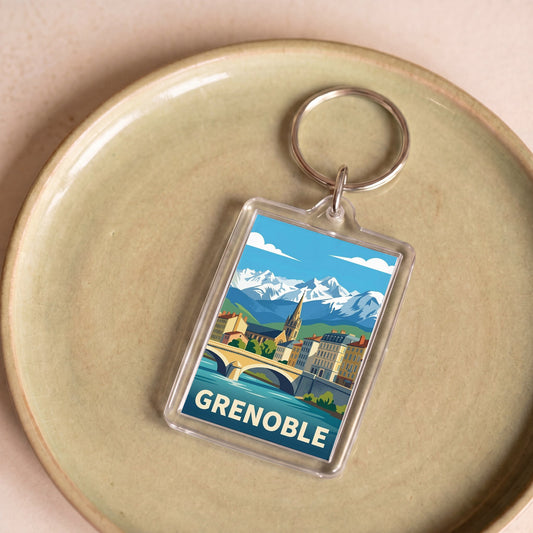 Porte-clés souvenir de la ville de Grenoble avec une illustration stylisée de son paysage urbain et montagneux.