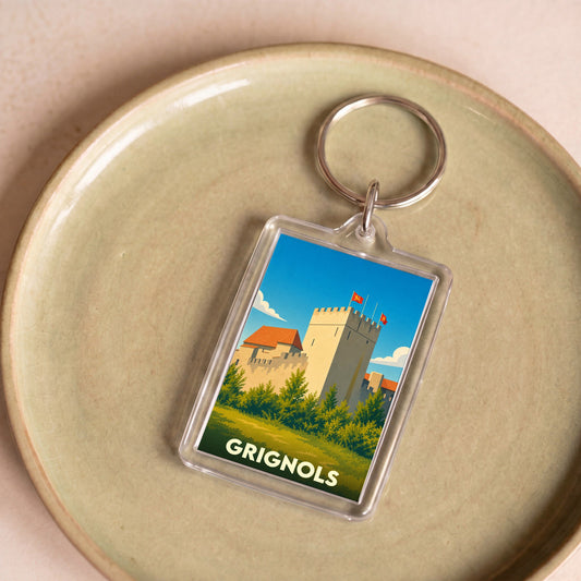 Porte-clés souvenir de la ville de Grignols avec une illustration stylisée d'un château.