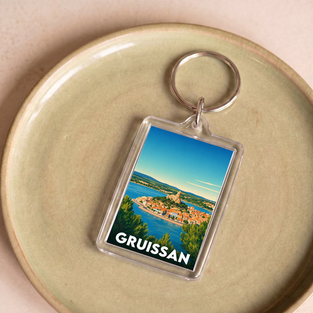 Porte-clés souvenir de la ville de Gruissan avec une illustration stylisée.