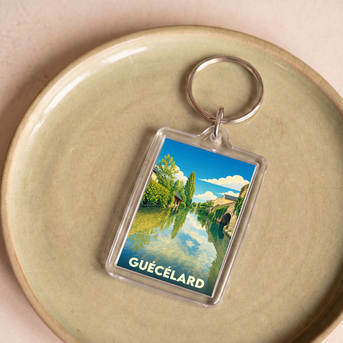 Porte-clés souvenir de la ville de Guécélard avec une illustration stylisée.