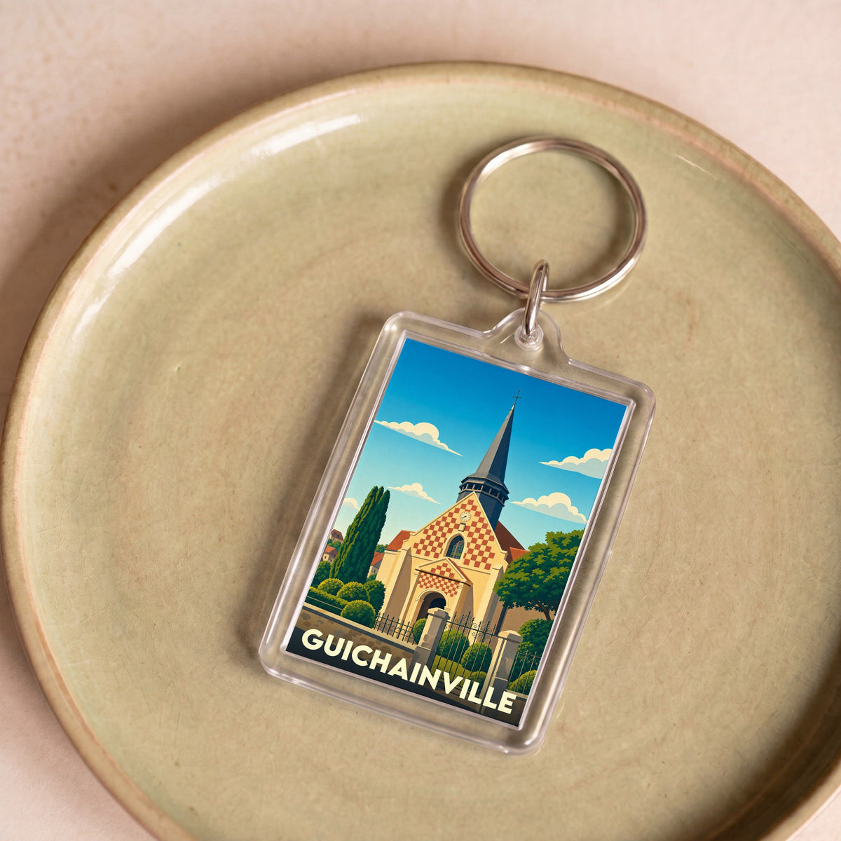 Porte-clés souvenir de la ville de Guichainville avec une illustration stylisée de son église.