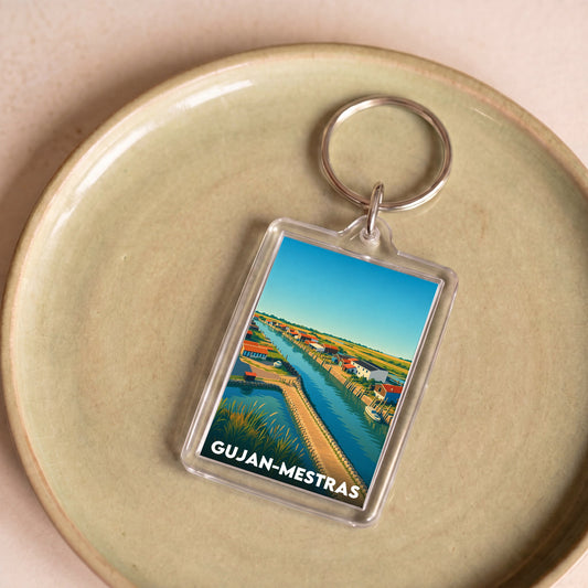 Porte-clés souvenir de la ville de Gujan-Mestras avec une illustration stylisée.