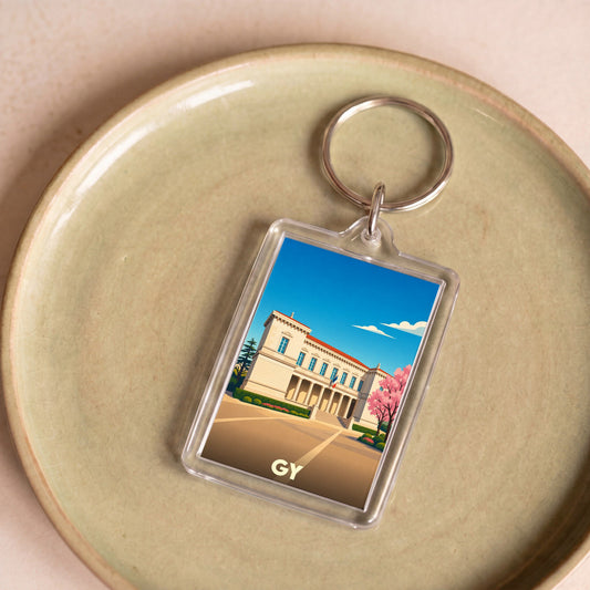 Porte-clés souvenir de la ville de Gy avec une illustration stylisée d'un bâtiment historique.