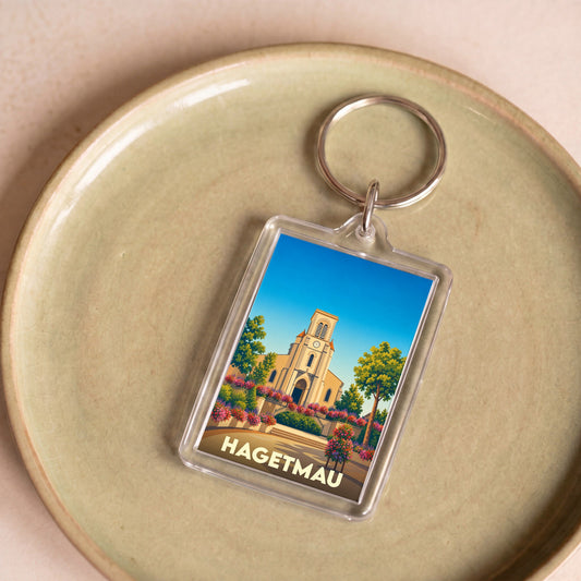 Porte-clés souvenir de la ville de Hagetmau avec une illustration stylisée de son église.
