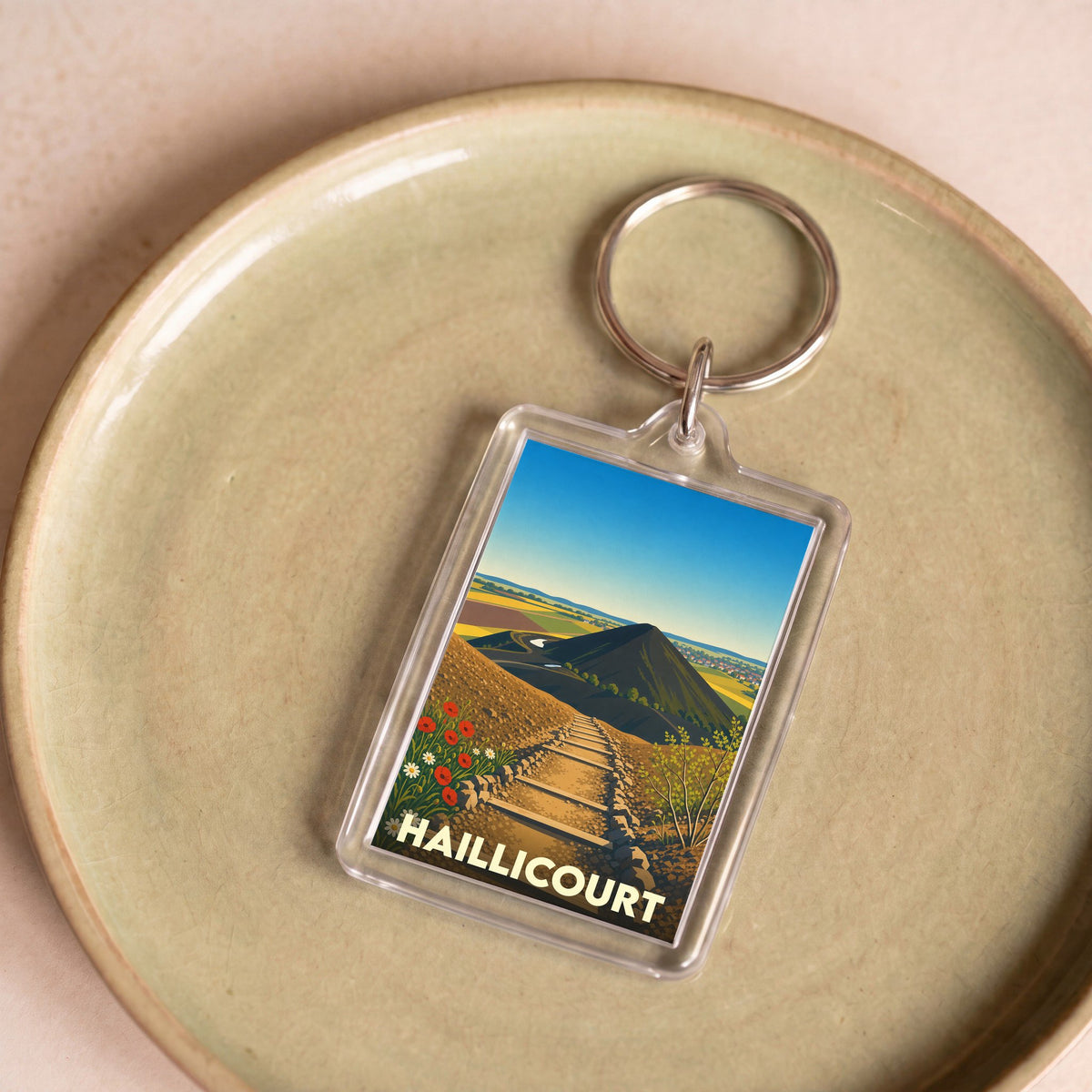 Porte-clés souvenir de la ville de Haillicourt avec une illustration stylisée de ses terrils.