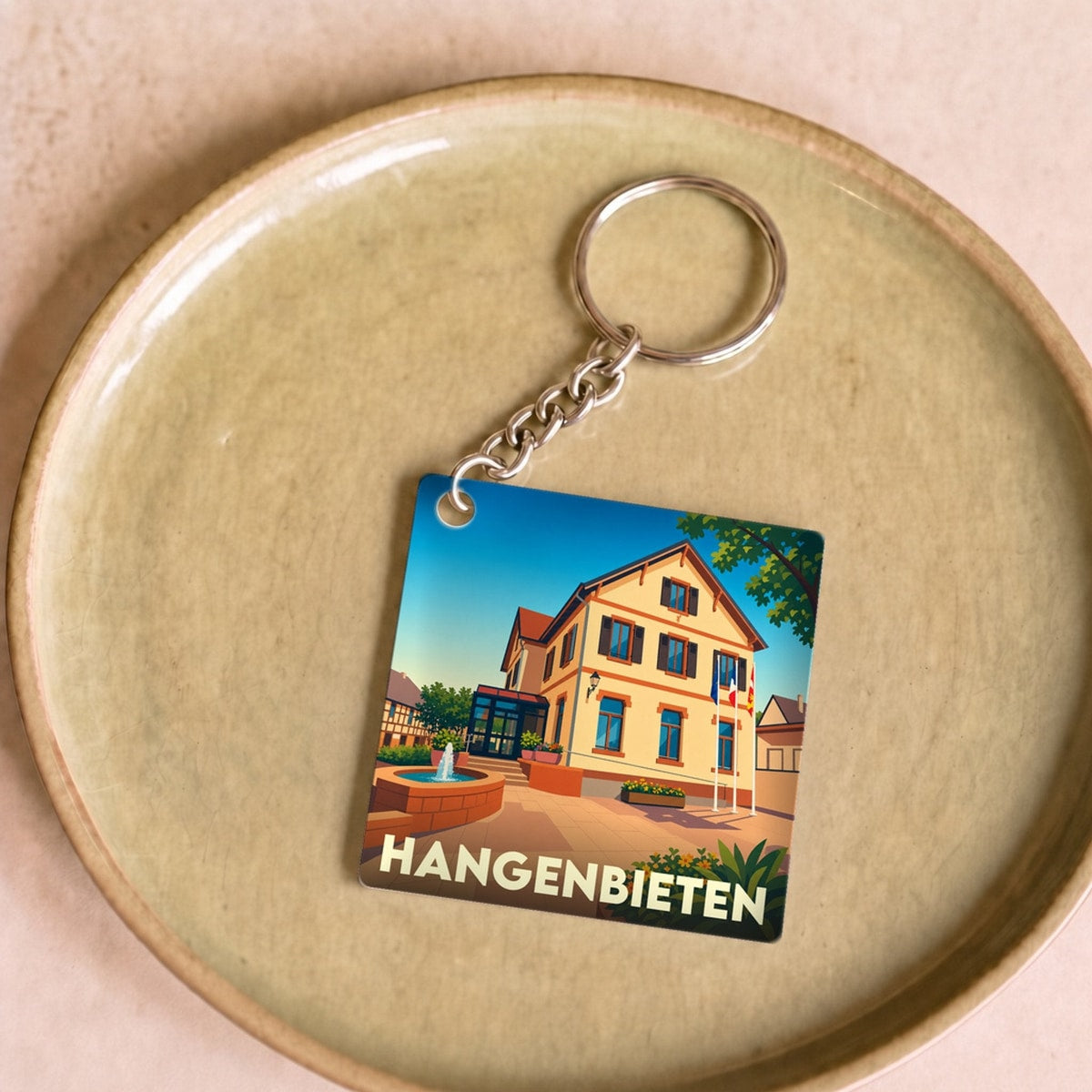 Porte-clés souvenir de la ville de Hangenbieten avec une illustration stylisée de sa mairie.