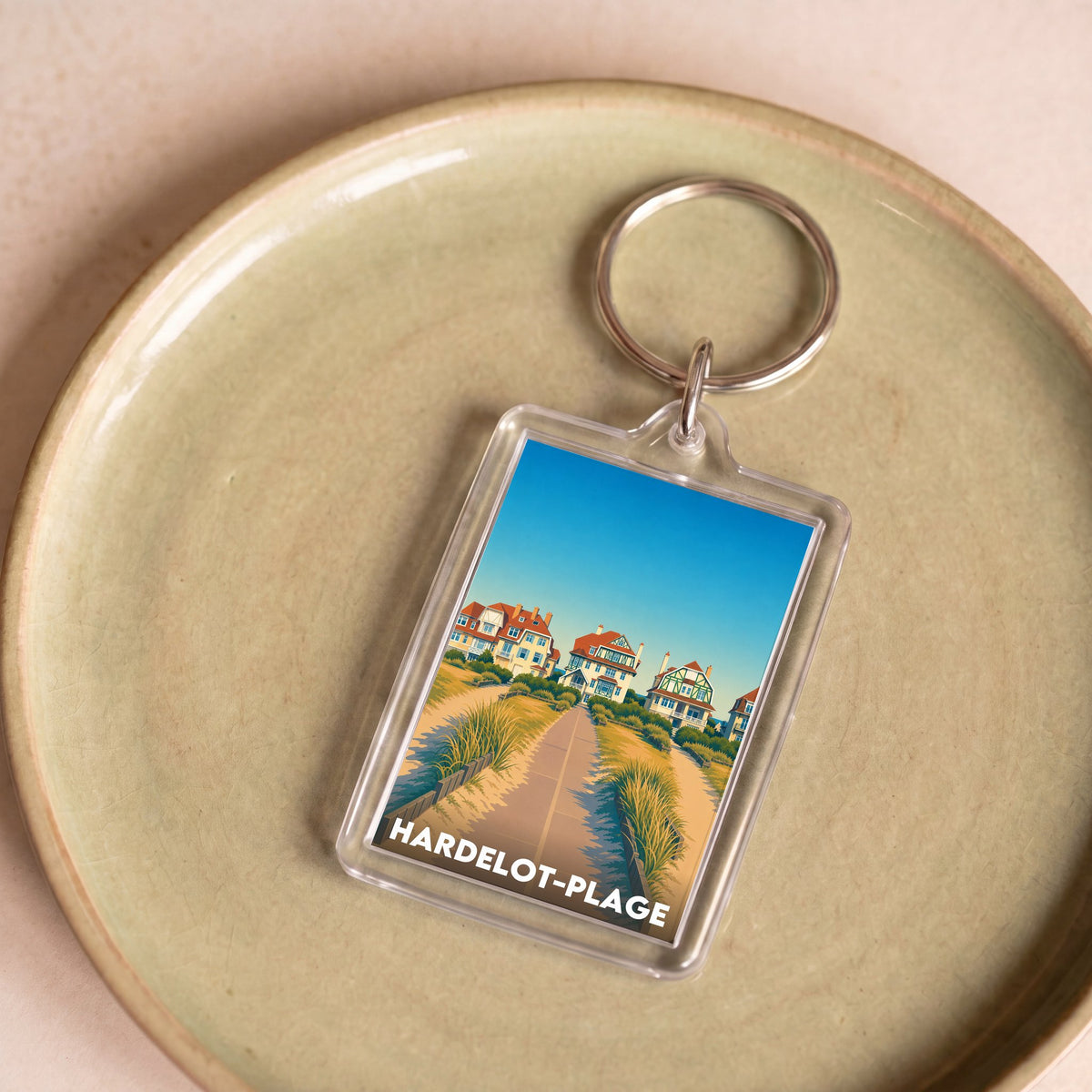 Porte-clés souvenir de la ville de Hardelot-Plage avec une illustration stylisée.
