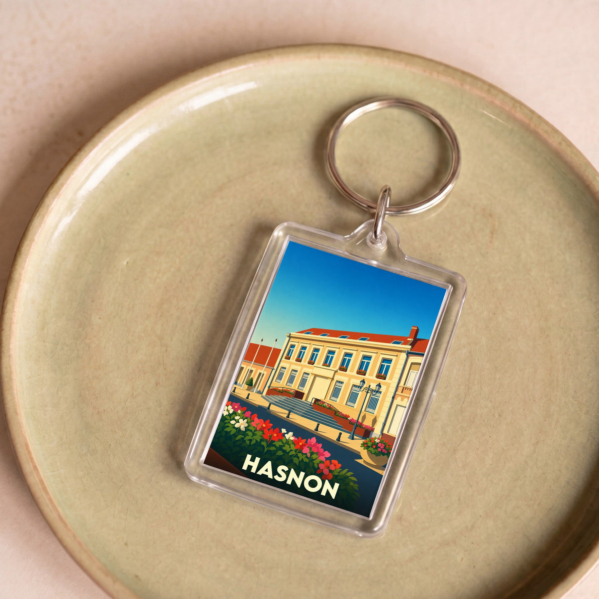 Porte-clés souvenir de la ville de Hasnon avec une illustration stylisée.
