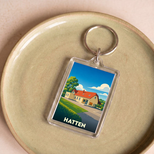 Porte-clés souvenir de la ville de Hatten avec une illustration stylisée.