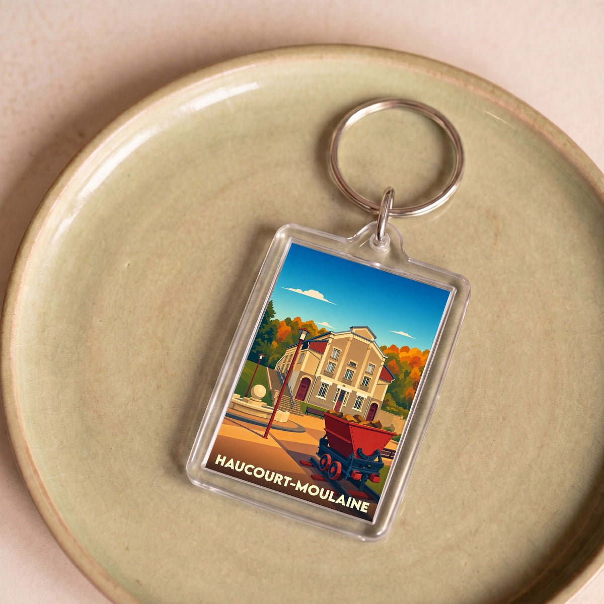 Porte-clés souvenir de la ville de Haucourt-Moulaine avec une illustration stylisée.
