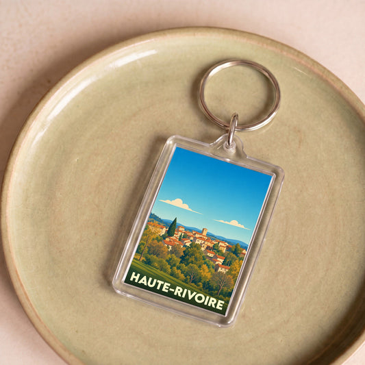 Porte-clés souvenir de la ville de Haute-Rivoire avec une illustration stylisée.