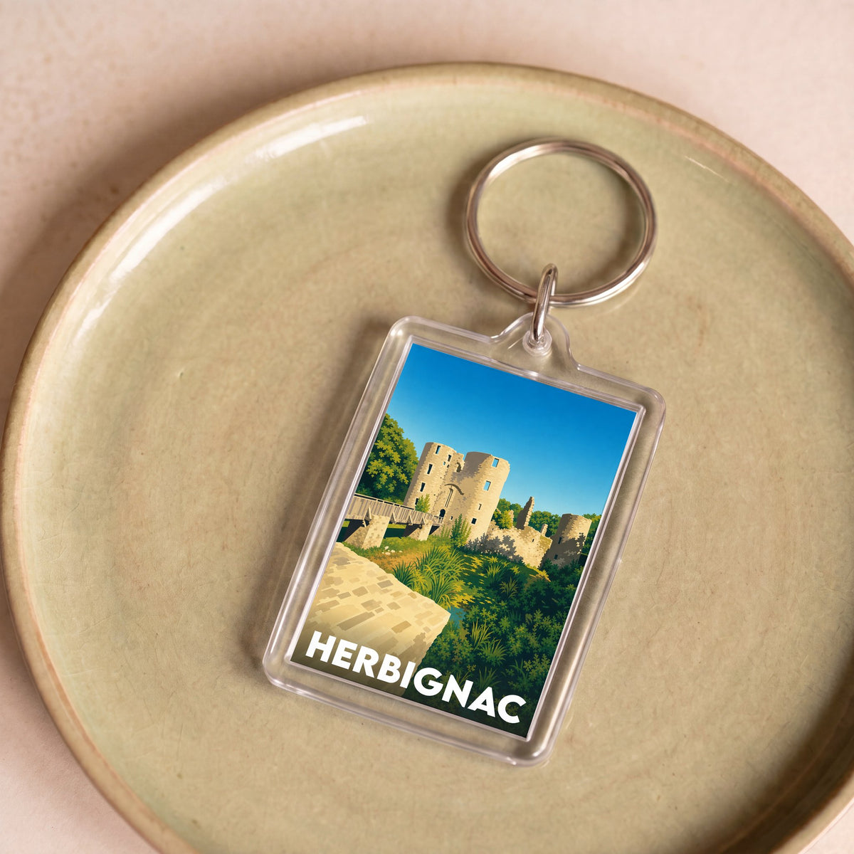 Porte-clés souvenir de la ville de Herbignac avec une illustration stylisée de son château.