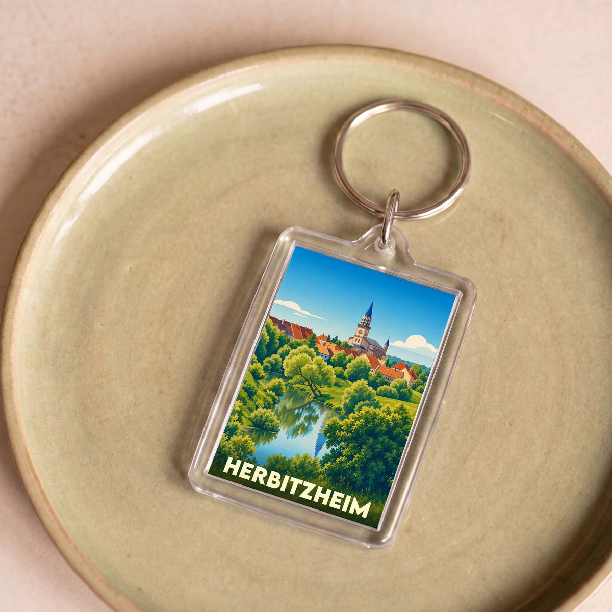 Porte-clés souvenir de la ville de Herbitzheim avec une illustration stylisée.