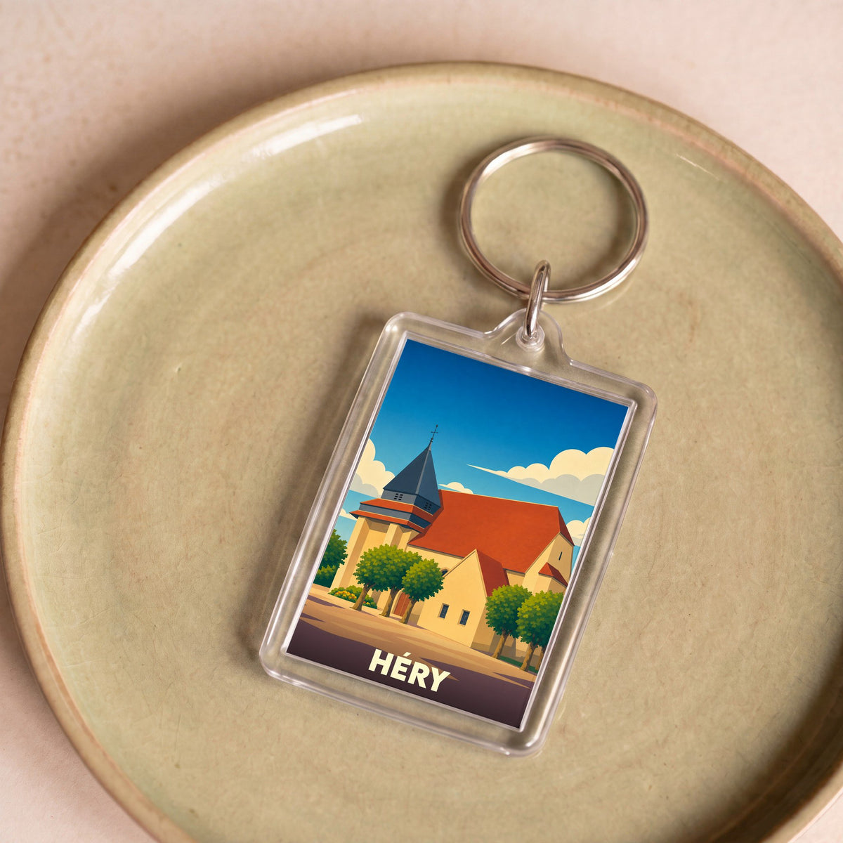Porte-clés souvenir de la ville de Héry avec une illustration stylisée de son église.