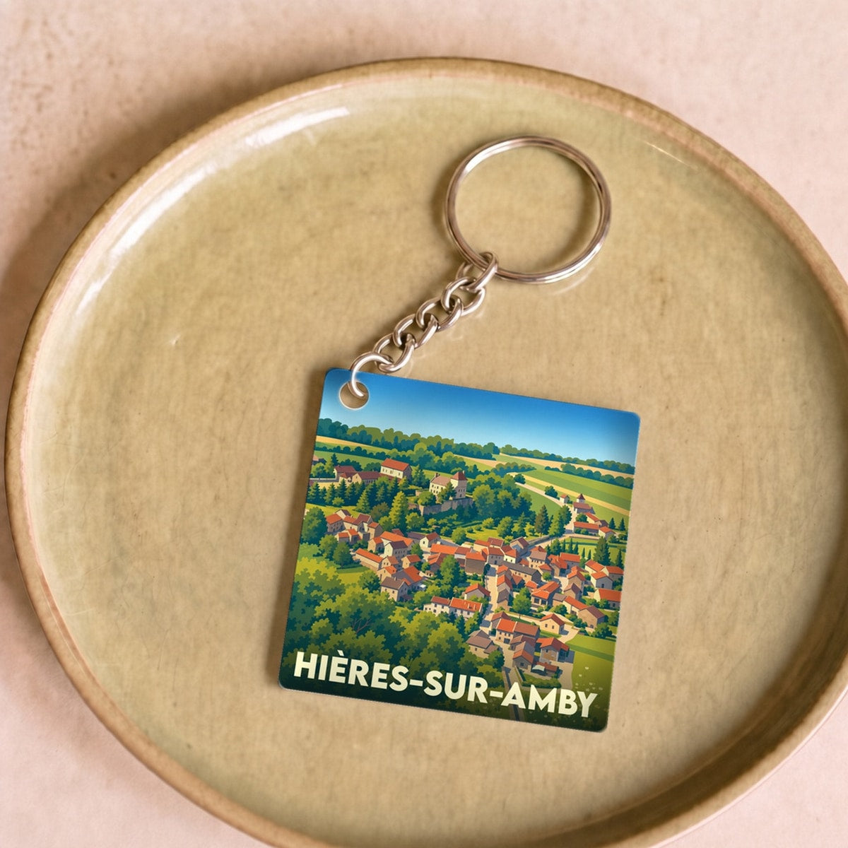 Porte-clés souvenir de la ville de Hières-sur-Amby avec une illustration stylisée.