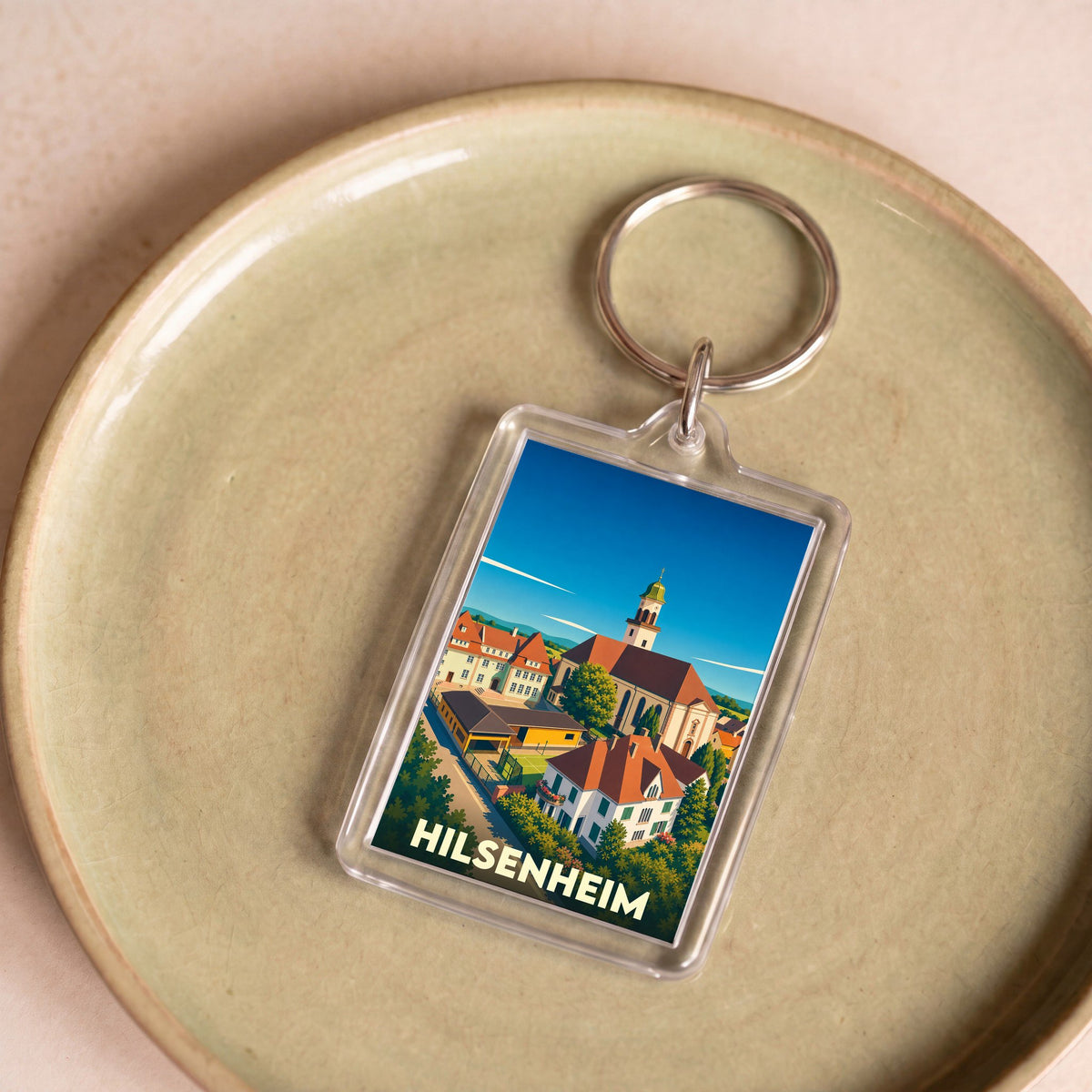 Porte-clés souvenir de la ville de Hilsenheim avec une illustration stylisée.
