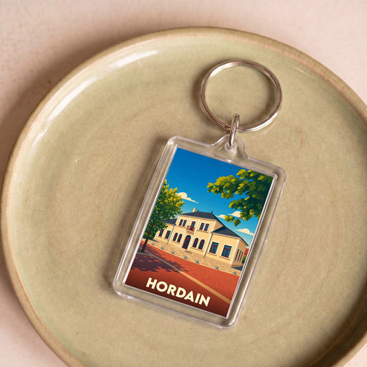 Porte-clés souvenir de la ville de Hordain avec une illustration stylisée d'un bâtiment emblématique.