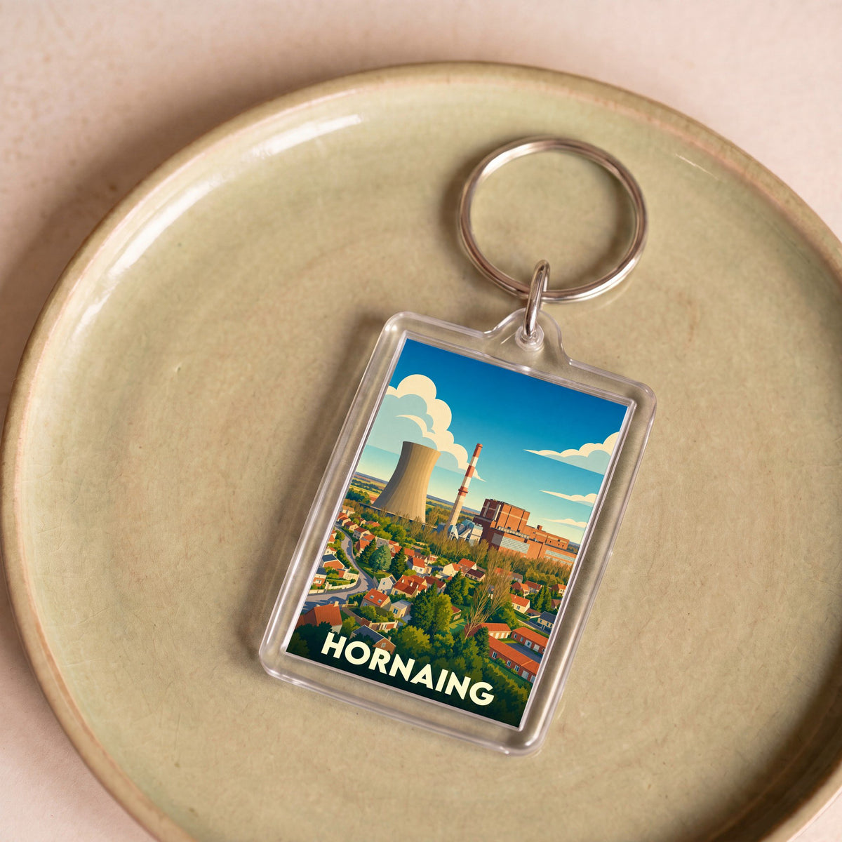 Porte-clés souvenir de la ville de Hornaing avec une illustration stylisée de sa centrale thermique.