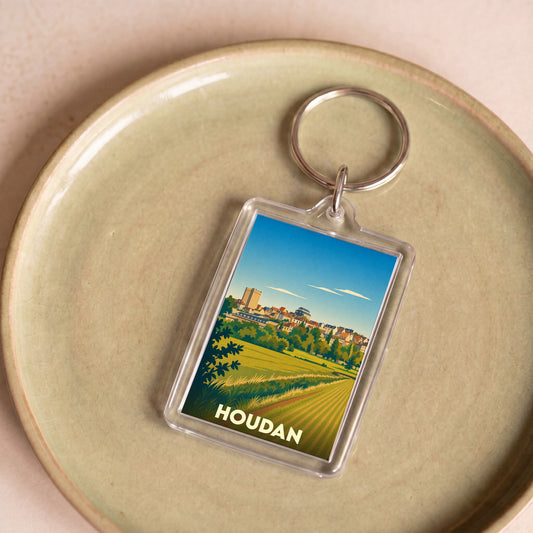 Porte-clés souvenir de la ville de Houdan avec une illustration stylisée de son paysage et de son donjon.