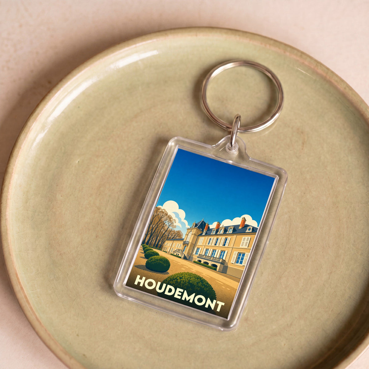 Porte-clés souvenir de la ville de Houdemont avec une illustration stylisée.