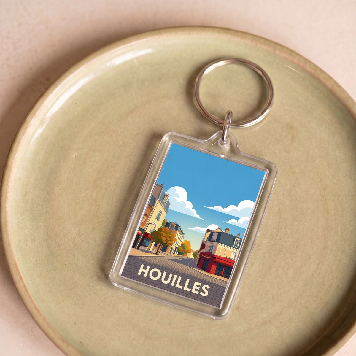 Porte-clés souvenir de la ville de Houilles avec une illustration stylisée.