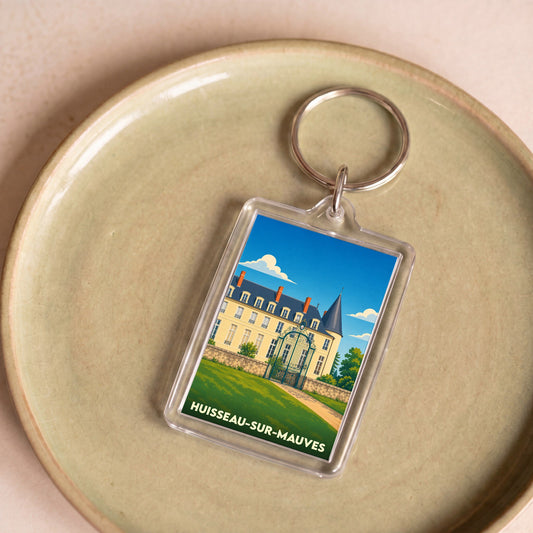 Porte-clés souvenir de la ville de Huisseau-sur-Mauves avec une illustration stylisée d'un château.