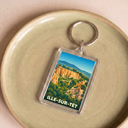 Porte-clés souvenir de la ville d'Ille-sur-Têt avec une illustration stylisée de ses formations géologiques.