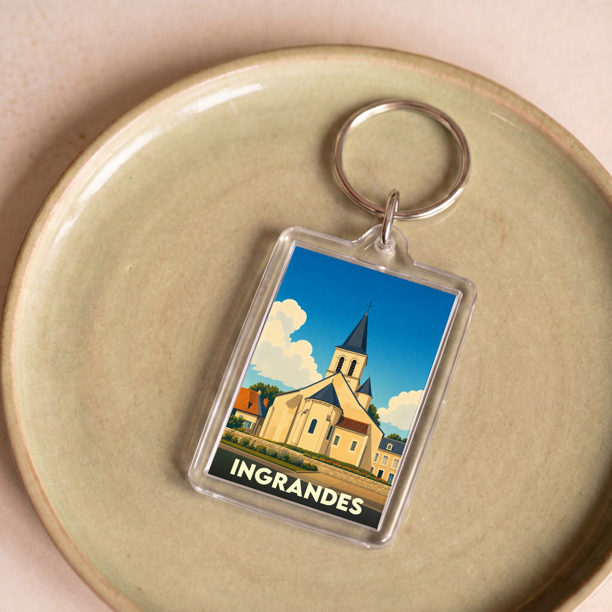 Porte-clés souvenir de la ville de Ingrandes avec une illustration stylisée de son église.