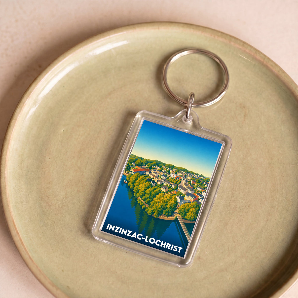 Porte-clés souvenir de la ville de Inzinzac-Lochrist avec une illustration stylisée d'un paysage urbain.
