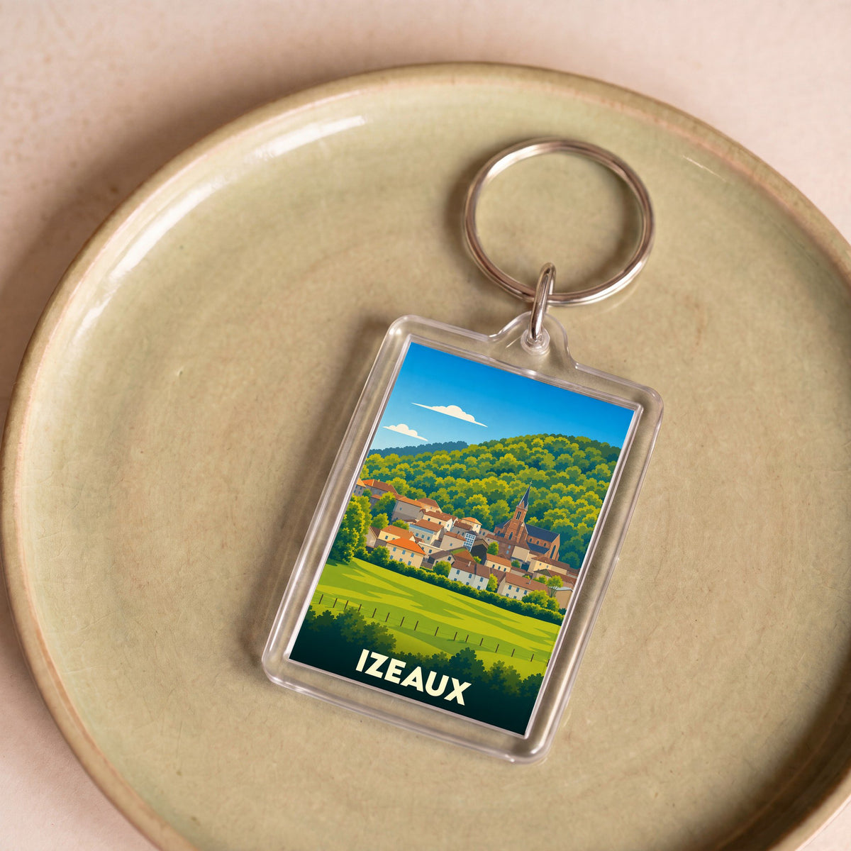 Porte-clés souvenir de la ville de Izeaux avec une illustration stylisée.